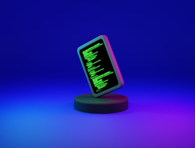 A smartphone displaying green computer code stands upright on a round, dark platform. The background fades from deep blue at the top to purple at the bottom, creating a futuristic and digital ambiance.